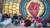 Migrants try to stay warm outside the Sacred Heart Church in El Paso, Texas, Dec. 18, 2022. Doctors, social workers, clergy and shelter directors say migrants are arriving at the U.S.-Mexican border in desperate need of trauma-informed medical and mental health treatment.