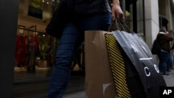 FILE - A shopper carries bags down Fifth Avenue on Black Friday, Nov. 25, 2022, in New York City. Holiday sales rose as shoppers showed some resilience during the most important shopping season despite surging prices on everything from food to rent.