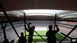 FILE - Para pekerja memindahkan perancah di stadion Al Bayt di Al Khor, Qatar, sekitar 50 kilometer utara Doha, Senin, 29 April 2019. (AP /Kamran Jebreili, File)