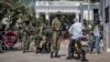 FILE - Soldiers check a motorcyclist at the entrance of the State House compound in Banjul, Gambia, Jan. 24, 2017.