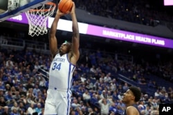 Kentucky's Oscar Tshiebwe (34) dunks during the first half of an NCAA college basketball game in Lexington, Ky. (AP Photo/James Crisp)