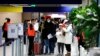 Penumpang yang datang dari China menunggu di depan area tes COVID-19 yang ditetapkan di bandara Roissy Charles de Gaulle, utara Paris, Minggu, 1 Januari 2023. (AP/Aurelien Morissard)