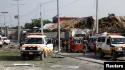 FILE - Somali police and paramedics are seen at the scene after a car exploded in a suicide attack near Mucassar primary and secondary school in Hodan district of Mogadishu, Somalia Nov. 25, 2021.