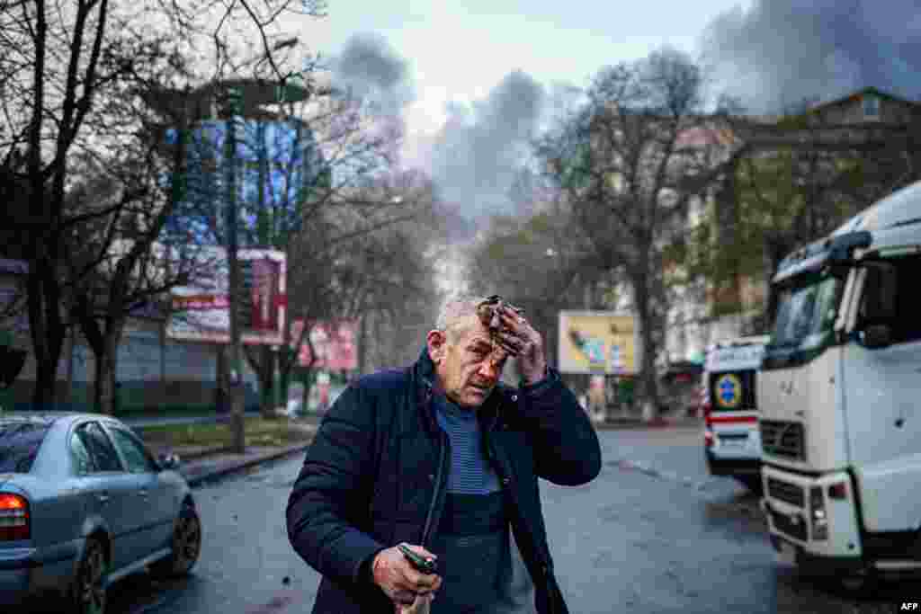 An injured man stands on a street after Russian shelling to Ukrainian city of Kherson, Dec. 24, 2022, where five were killed and 20 injured.