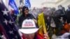 Para loyalis mantan Presiden Donald Trump mencoba mendobrak barikade polisi di Gedung Capitol, Washington, dalam aksi penyerbuan terhadap gedung tersebut pada 6 Januari 2021. (Foto: AP/John Minchillo) 