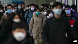 资料照 - 2022年12月20日的北京街头，带口罩的通勤者在交通高峰期匆忙赶去上班。在突然放开了执行将近3年的严格封控政策后，中国多地新冠感染病例暴增，并且出现了奥密克戎病毒的变异毒株。