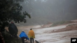 Orang-orang berjalan di sekitar jalan yang terhalang oleh tanah longsor di San Cristobal Verapaz, 7 November 2020, setelah Badai Eta. (Foto: AP)