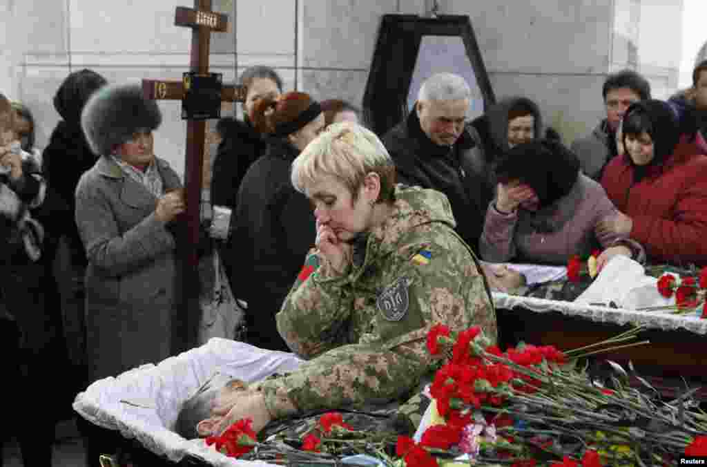 People mourn during a funeral ceremony for Ruslan Boburov and Vadym Zherebylo, members of the self-defense battalion "Aydar," who were killed while fighting in eastern Ukraine, Feb. 2, 2015.