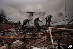 Firefighters work to extinguish a fire after a Russian attack destroyed the building of a Culinary School in Kharkiv, Apr. 12, 2022.