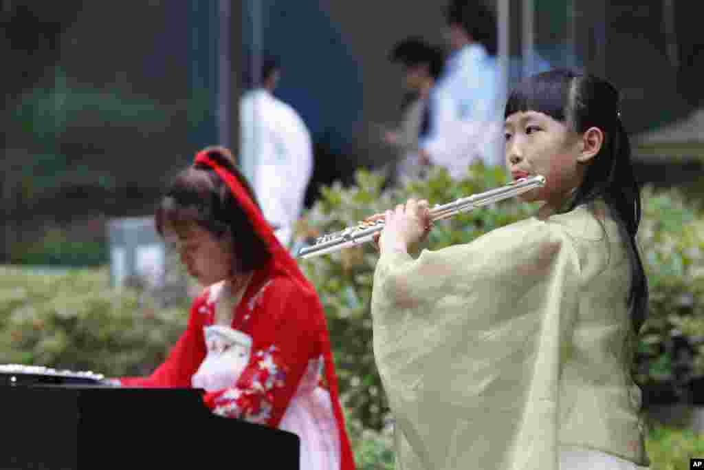 2018年6月9日,青岛的上海合作组织(SCO)峰会媒体中心,音乐人演奏古筝和长笛。此次上合组织青岛峰会在官媒渲染下盛况空前,中国为与会国代表举行了欢迎宴会,还有文艺演出和焰火表演。有一些推特用户以此和同一时段举行的工业7国峰会做比较,赞扬G7峰会之简朴,批评青岛峰会之奢华。有人说:“西方富国开穷会,东方穷国开富会。”
