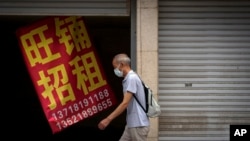 一名男子走過北京街頭一家招租的商店。 （2022年8月17日）