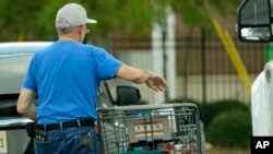 A shopper removes his purchases from his cart in Jackson, Miss., Wednesday, Oct. 12, 2022.