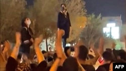 This image from a UGC video shows Iranian women protesting in a street in the central city of Yazd, Iran, on Sept. 26, 2022, as they rally following the death of Mahsa Amini after her arrest for allegedly breaching Iran's strict rules on hijab headscarves.