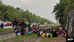 MALAYSIA-MYANMAR-PRISON-IMMIGRATION-ROHINGYA This handout taken and released by the Royal Malaysia Police on April 20, 2022 shows Rohingya refugees, who had escaped from Malaysian Immigration's temporary Sungai Bakap depot, detained on the side of a highw