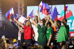 Mantan senator Ferdinand "Bongbong" Marcos Jr., tengah-kiri, dan pasangannya Wali Kota Davao Sara Duterte pada 2022. (Foto: AP)