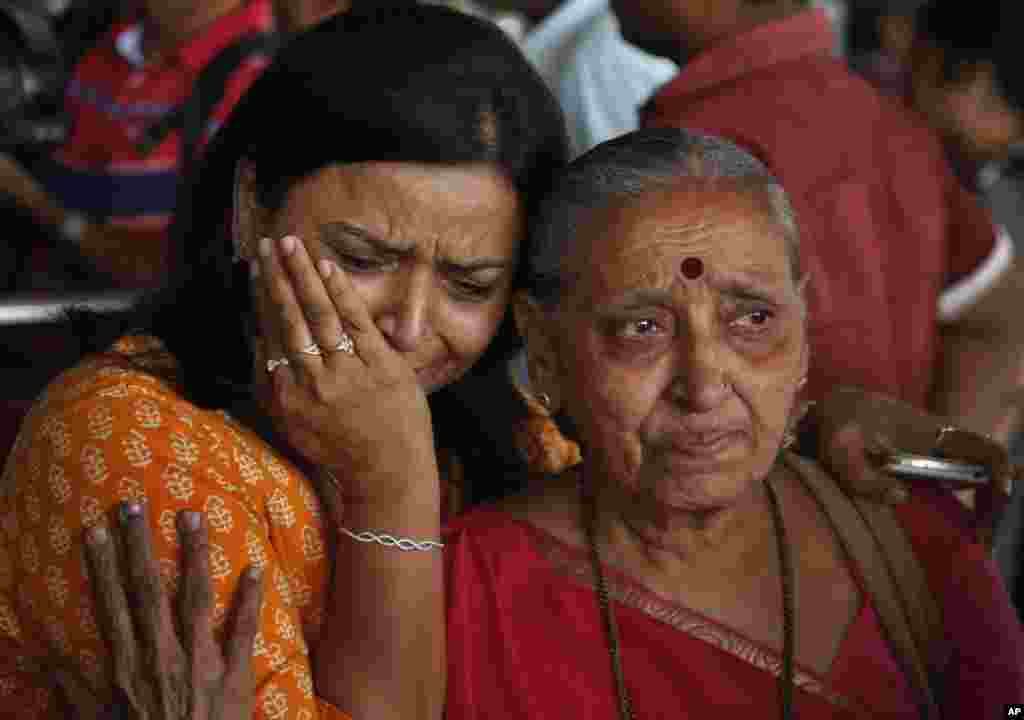 An Indian woman cries as her relative, right who was on pilgrimage in Nepal during Saturday’s earthquake, returned at the airport in Ahmadabad, India.