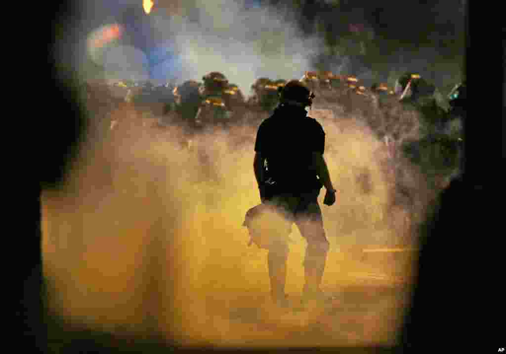 Police fire teargas as protesters converge on downtown following Tuesday's police shooting of Keith Lamont Scott in Charlotte, N.C., Sept. 21, 2016.
