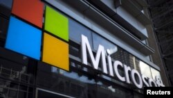 FILE - A Microsoft logo is seen on an office building in New York City in this July 28, 2015 file photo. Microsoft Corp announced more big cuts to its smartphone business on Wednesday. 