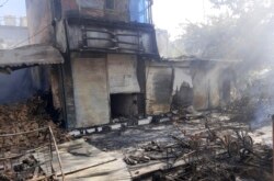 Smoke rises from damaged shops after fighting between Taliban and Afghan security forces in Kunduz city, northern Afghanistan, Sunday, Aug. 8, 2021. (AP Photo/Abdullah Sahil)