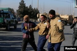 Seorang petugas kemananan terluka dan diselamatkan dari Intercontinental Hotel di Kabul, Afghanistan, 21 Januari 2018.