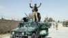 FILE - An Afghan soldier raises his hands as a victory sign after Kunduz was retaken from Taliban forces, Oct. 2, 2015. 