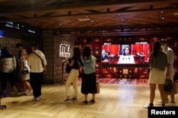 마스크를 쓴 홍콩 시민들이 지난달 방역 완화 방침에 따라 문을 연 영화관에 입장하고 있다. (자료사진)