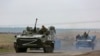 FILE - Russian military vehicles move on a road in an area controlled by Russian-backed separatist forces near Mariupol, Ukraine, April 18, 2022. Some Ethiopians, eager to join Russia's aggression aganst Ukraine, have been lining up at the Russian embassy in Addis Ababa.