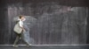 FILE - A woman walks past graffiti on an immigration detention hotel in Melbourne on March 24, 2022.