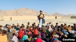 Matiullah Wesa, aktivis pendidikan Afghanistan, membacakan buku untuk siswa di kelas terbuka di pedesaan Afghanistan. (Foto:Courtesy/Matiullah Wesa)
