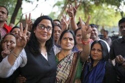 Asha Devi (tengah), ibu dari korban pemerkosaan beramai-ramai pada 2012, mengacungkan tanda kemenangan setelah pemerkosa anaknya dihukum gantung, di New Delhi, India, 20 Maret 2020. (Foto: AP)
