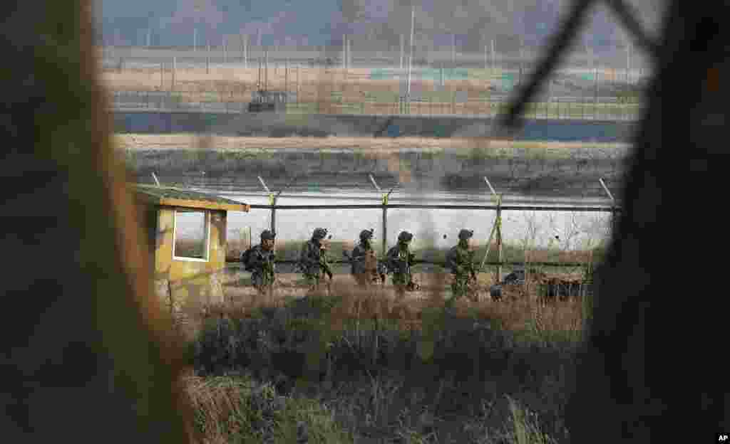 2013年3月27日,韩国士兵在韩国坡州板门店边界村附近沿着铁丝网巡逻。