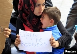 Seorang migran memegang kertas dengan tulisan di depan stasiun kereta Keleti di Budapest, Hungaria, 4 September 2015.