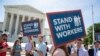 People gather at the Supreme Court awaiting a decision in an Illinois union dues case, Janus vs. AFSCME, in Washington, June 25, 2018. The Supreme Court says government workers can't be forced to contribute to labor unions that represent them in collective bargaining, dealing a serious financial blow to organized labor.