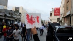 Seorang demonstran anti-pemerintah memegang foto ulama Syiah Sheikh Nimr al-Nimr, yang pada hari Sabtu (2/1) diumumkan akan dieksekusi, dalam sebuah demonstrasi damai di Daih, Bahrain, 2 Januari 2016.