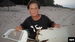 Foto yang dirilis tanggal 10 Juni 2016 ini menunjukkan Blaine Gibson tengah memegang kepingan pesawat MH370 yang ditemukan di Madagaskar