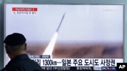 一名男子在韩国首尔的火车站观看朝鲜导弹发射（2016年3月18日）