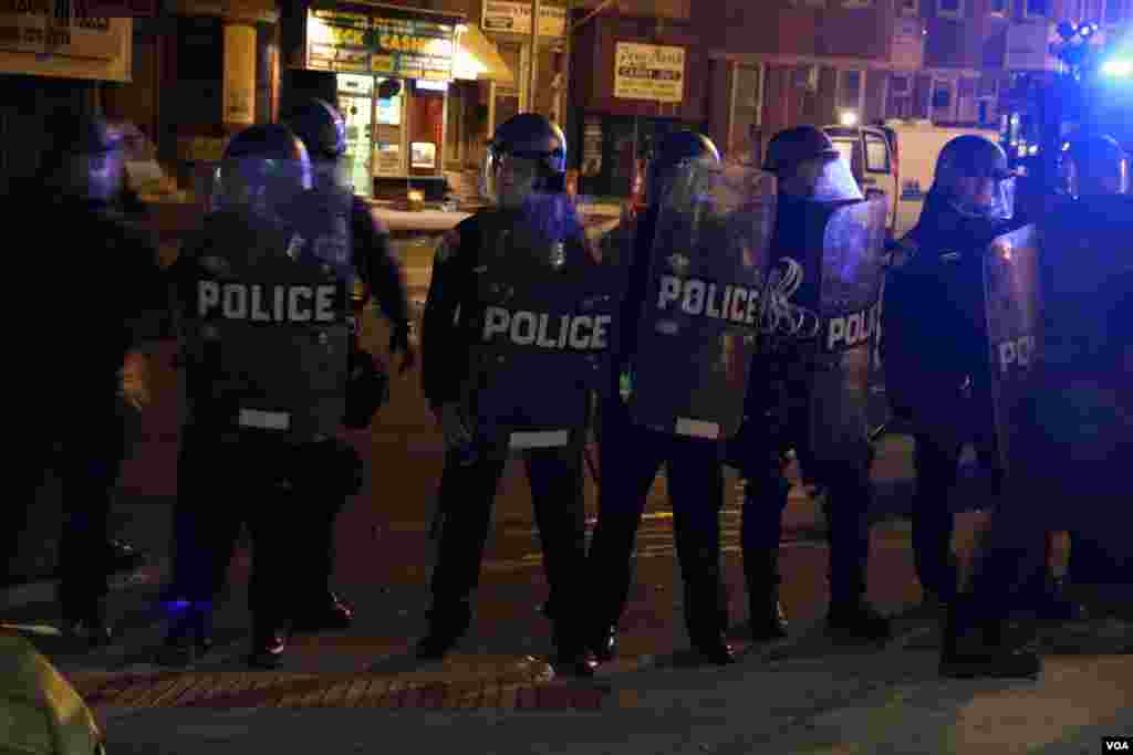 Riot police form a line to push back protesters and media, Baltimore, April 28, 2015. (Victoria Macchi/VOA News)