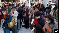 Masyarakat Jepang mengheningkan cipta dan berdoa untuk mengenang korban gempa bumi dan tsunami di daerah pertokoan Ginza, Tokyo.