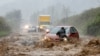 A resident helps free a stranded car as Tropical Storm Helene strikes Boone, North Carolina