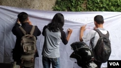 Aksi penggalangan tanda tangan untuk mendesak aparat mengusut kasus kekerasan jurnalis di depan kantor AJI Jakarta. (Foto: VOA/Sasmito)