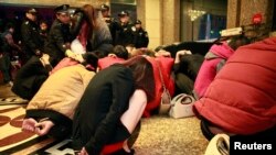 在广东省东莞一家酒店扫黄行动中，警察清点被他们抓住的疑似性工作者的人数。（2012年2月9日）