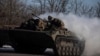 Ukrainian service members ride atop of a BMP-2 infantry fighting vehicle near a frontline in Donetsk region, Ukraine, Feb. 8, 2023.