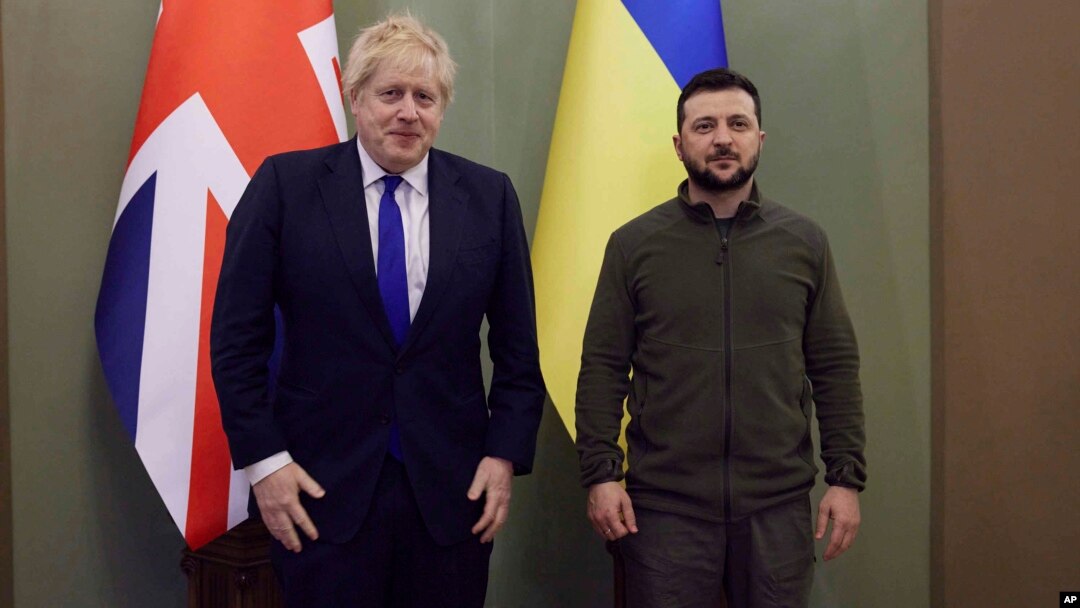 Nan foto sa a ke Biwo de Pres Prezidansyel Ikrenyen bay jounalis yo, Premye Minis Britanik la Boris Johnson (a goch) ak Prezidan Ikrenyen an Volodymyr Zelenskyy poze pou yon foto nan vil Kyev, kapital Ikren, Samdi 9 Avril 2022. 