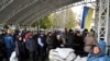 FILE - People queue to buy mainly medicine and other goods in the town of Bucha, northwest of Kyiv, Ukraine, April 3, 2022.