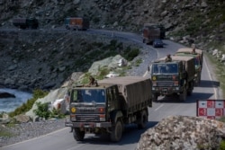 FILE - An Indian army convoy moves on the Srinagar- Ladakh highway at Gagangeer, northeast of Srinagar, Indian-controlled Kashmir, Sept. 9, 2020.