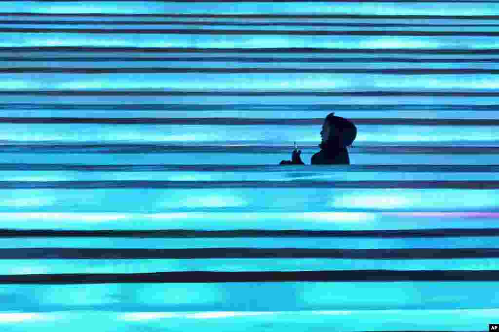 A visitor slides down blocks of ice during the opening ceremony of the Harbin Ice and Snow World in Harbin in China's Heilongjiang province.