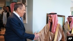 سرگئی لاوروف، وزیر خارجه روسیه، سمت چپ، و فیصل بن فرحان آل سعود، وزیر خارجه عربستان سعودی، در حاشیه نشست وزیران خارجه بریکس در کیپ تاون.