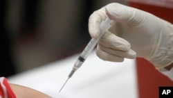 FILE - This Jan. 23, 2020 file photo shows a patient receiving a flu vaccination in Mesquite, Texas.
