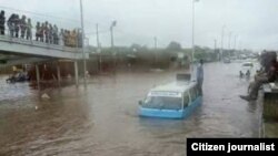 Táxi parado no meio de uma estrada de Luanda inundada devido às chuvas (Foto de Arquivo)