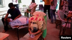 Istri dari pria yang bernama Nanhe Pal, 52, menangis saat memohon bantuan oksigen untuk suaminya, yang menderita gangguan pernapasan di Gurudwara (kuil Sikh), di tengah penyebaran COVID-19, di Ghaziabad, India, 3 Mei 2021. (Foto: Reuters)
